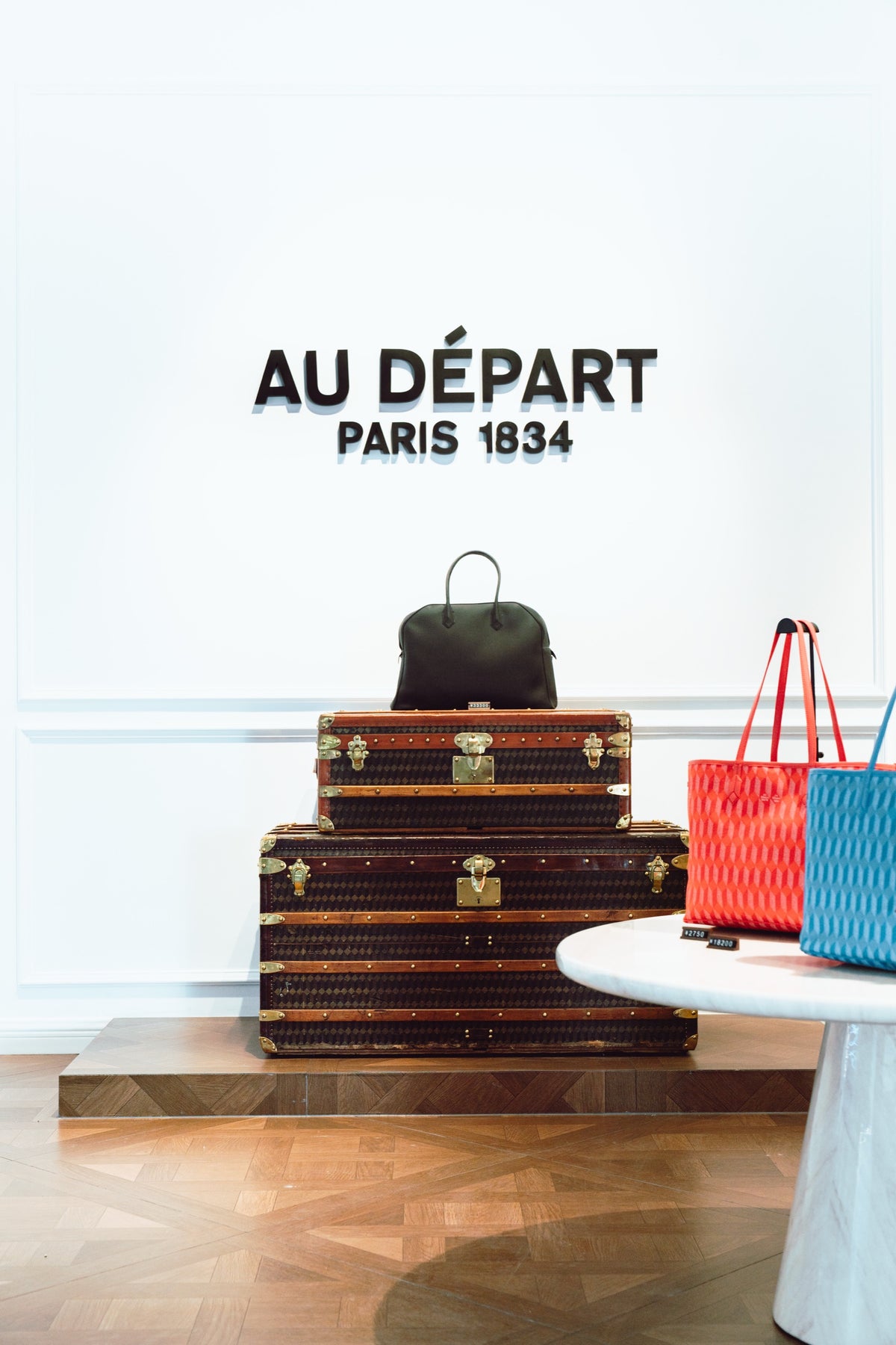 Au Départ Paris 1834 signage above stacked heritage trunks